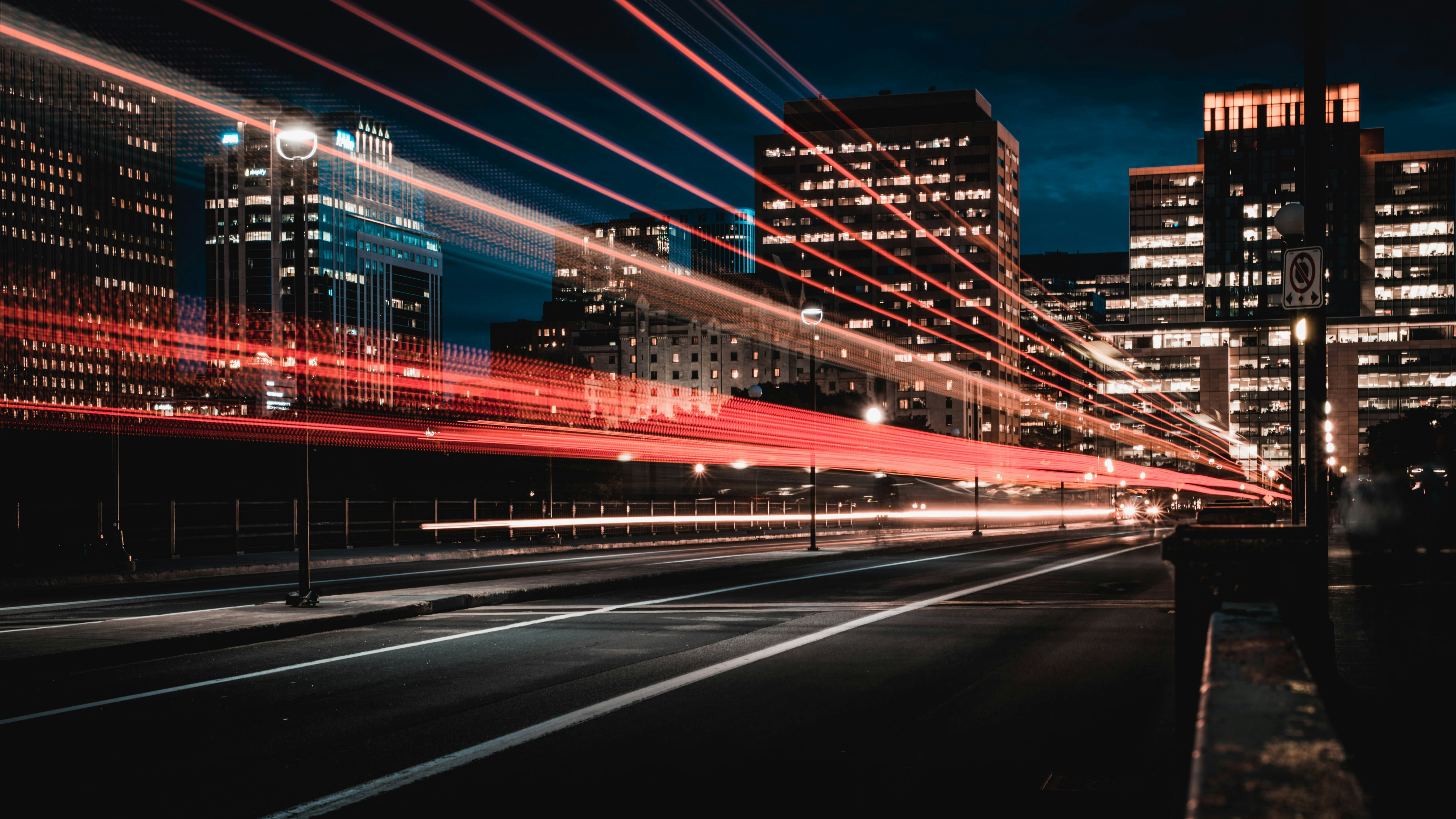 a busy street with tall buildings with lights in the windows at night