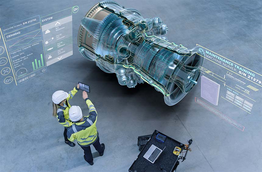 two workers in hardhats and high vis vests looking at data from a piece of industrial equipment