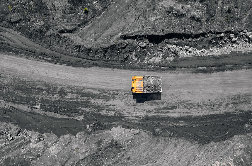 an aerial view of a single yellow dump truck on a mine site