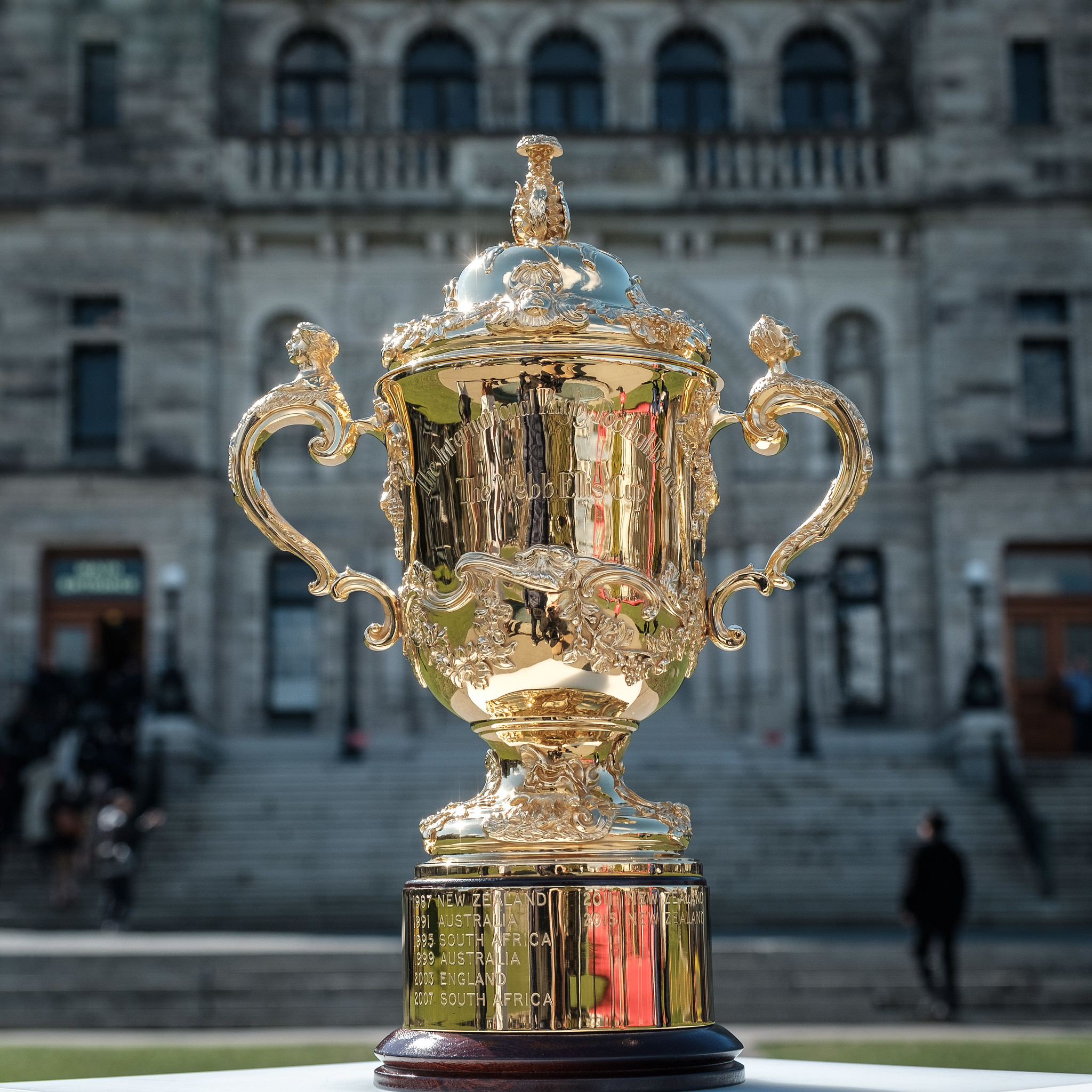 The Webb Ellis Cup in front of a grey building.